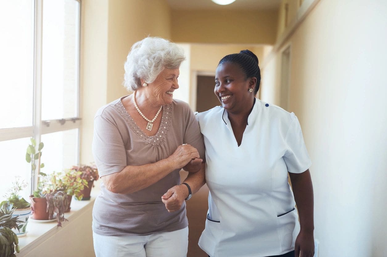 Two women are walking together in a hallway.