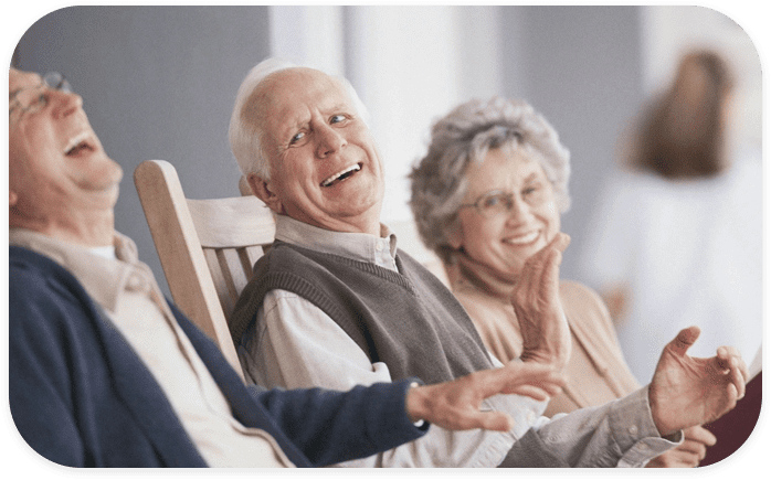 An older man and woman sitting in a chair.